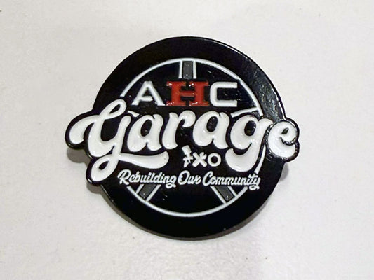Front view of AHC Garage official enamel pin collectible