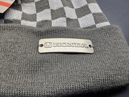 Close-up of Honda logo plate on white and gray knit beanie